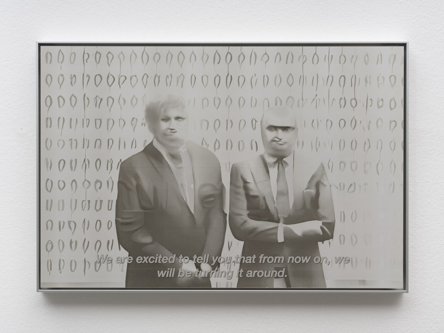 A laser-cut aluminium panel: two figures in suits before a wall of soft repeated marks, subtitled “We are excited to tell you that from now on, we will be turning it around.”